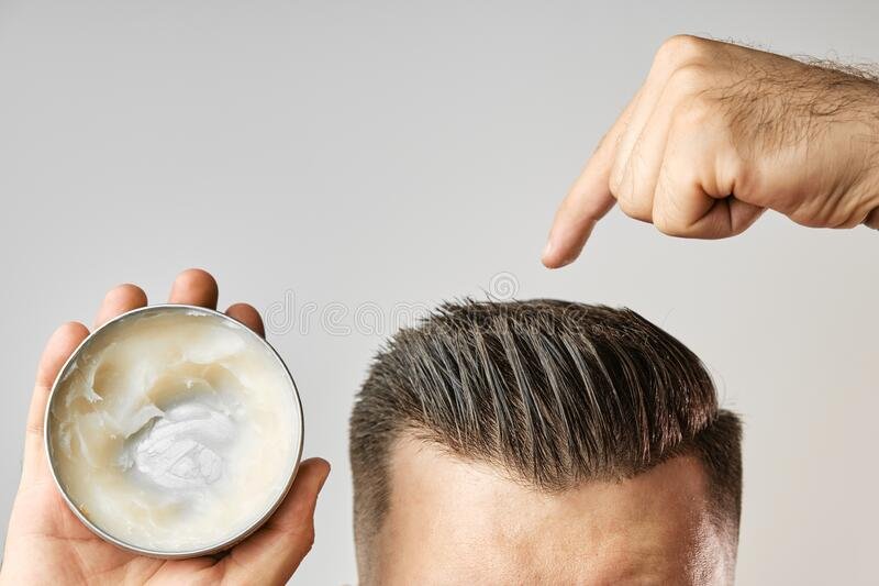 homem que aplica um gel de cera bagaco argila ou musso caixa metal redondo para estilar o cabelo apos corte na barbearia 197063355
